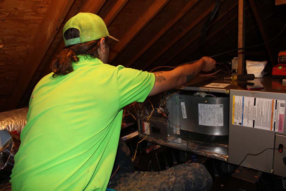 Technician inspecting a heating unit in Russellville, KY