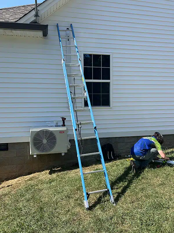 Top Notch tech working outside of residential home in Bowling Green, KY. Installing heat pump.