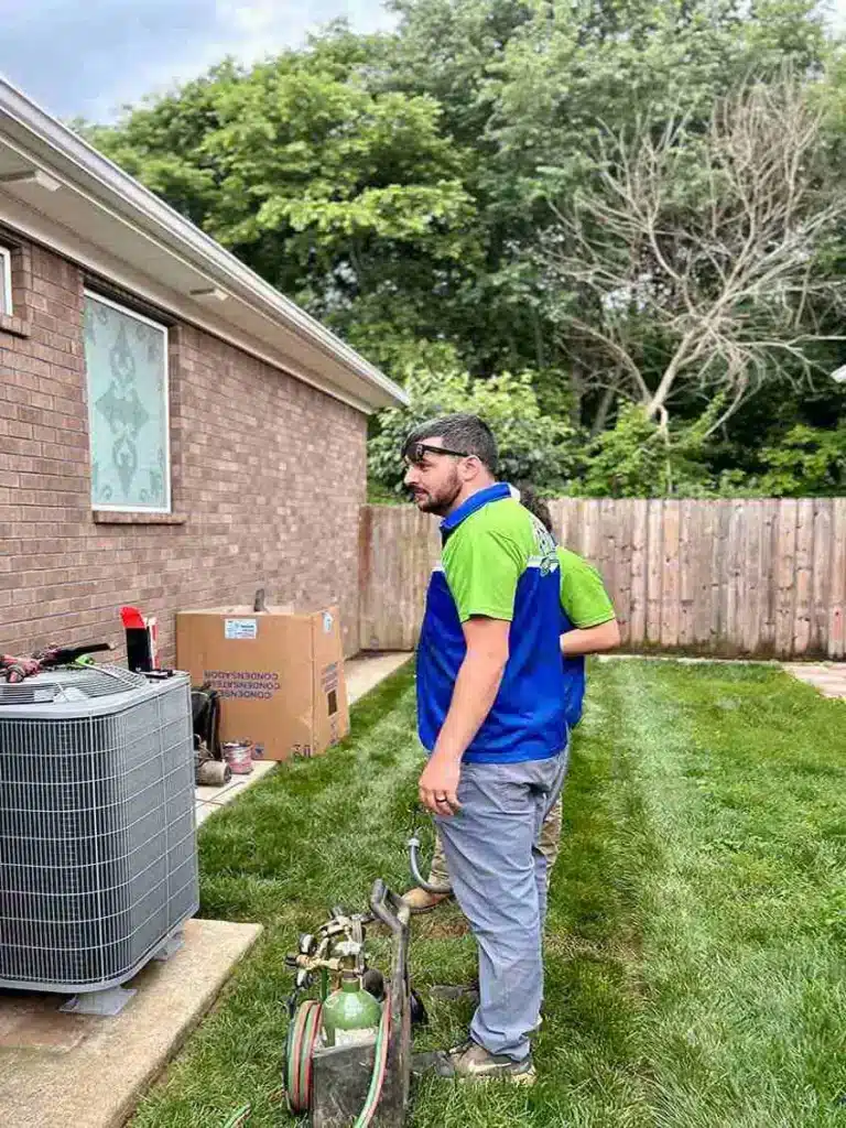 Top notch technician servicing AC outside of residential home.
